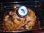Brathähnchen mit aufgestecktem Bratenthermometer im Backofen, fast fertig