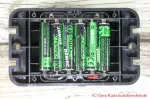 Unterseite des Vertreibers mit geöffnetem Batteriefach und sechs eingelegten AAA-Batterien