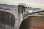 Badreiniger Herstellen verkalkter Bereich um einen Wasserhahn